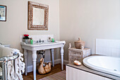 Country-style bathroom with antique washbasin and white bathtub