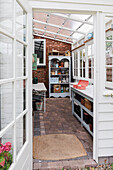 Entrance area to light-flooded conservatory with brick walls