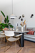 Modern dining area with golden metal chairs and light grey bench seat