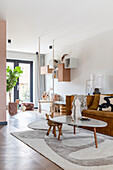 Modern living room with brown sofa, hanging shelves and large rug in earthy tones