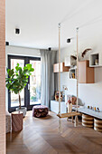 Modern children's room with swing, wooden herringbone floor and wall shelves