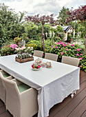 Terrace with covered garden table surrounded by hydrangeas