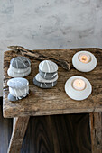 Painted pebbles and candle holders on a rustic wooden bench