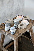 Wooden table with maritime decorations made of painted stones, cardboard in the shape of fish and tea lights