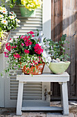 Flower arrangement with red pentas and eucalyptus on wooden stool