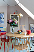 Dining table with wooden chairs, fruit bowl and bouquet of flowers