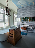 Modern bathroom with free-standing bathtub and geometric wall tiles