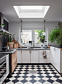 Bright kitchen with skylight, black and white chequerboard floor and wooden elements