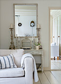 Bright vintage-style living room with antique mirror and candle holders