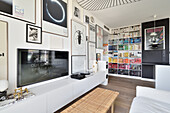 Modern eingerichtetes Wohnzimmer mit Bücherregal und Bildern