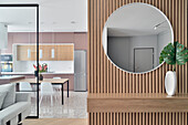 Modern flat furnishings with round wall mirror and wood panelling