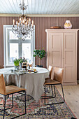 Dining room with chandelier, table with linen tablecloth and oriental rug