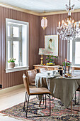 Dining room with chandelier, wooden walls and patterned carpet