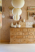 Wooden chest of drawers with small drawers, felt lamps and ceramic vases