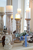 Wooden candlestick, bust and antique bowl with base and eucalyptus branches on mantelpiece