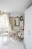 White living room in shabby chic style with antique grandfather clock and small round table