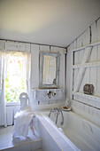 Bright bathroom with bathtub and antique mirror