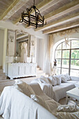 Bright vintage-style living room with white sofa and wooden beamed ceiling