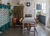 Dining room with concrete floor, sorting cupboard and open passageway to the kitchen