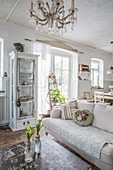 Open-plan living area with vintage furniture and crystal chandelier