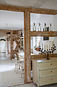 Rustic dining room with wooden beams, display cabinet and antique candlestick