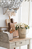 Rustic table with wooden boards, cutlery holder and roses in a bucket