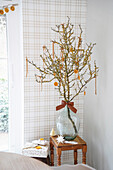 Branches with dried orange slices in a glass vase on a wooden table