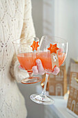 Two glasses with orange-coloured drinks and name tags