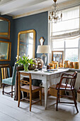 Room with vintage table, mirrors, chandelier and bouquet of tulips