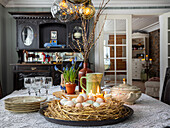 Easter decoration with eggs and candles on dining table in rustic dining room