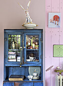 Blue vintage kitchen cabinet with china and decorations