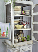 Vintage display cabinet with tableware, glasses and decorative objects