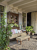 Covered terrace with vintage furniture and potted plants