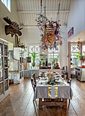 Country-style dining room with high ceiling, rustic wooden table and colorful Christmas decorations