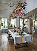 Large dining table with rustic Christmas decorations on a hanging ladder