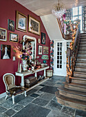 Hallway with red wall, picture gallery, antique furniture and Christmas decorations