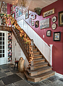 Staircase decorated for Christmas with fairy lights and picture wall