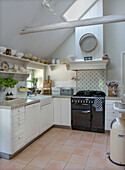 Bright country kitchen with rustic wooden beams and black gas stove