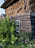 Old wooden shed with hay bales and cottage garden