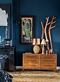 Bedroom with dark blue wall, wooden floor and mosaic picture