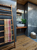 Modern bathroom with wooden floor and towel ladder