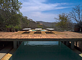 Wooden walkway over pool with sun loungers in rural area, Mexico