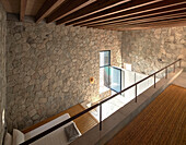 Sleeping area with double bed and stone walls, mezzanine in private house, Mexico