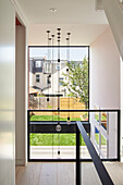 View through the glass balustrade in the hallway to the garden, Coral Cube House in London