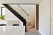 Essbereich mit Blick auf Treppe, Glasgeländer und integriertem Weinregal
