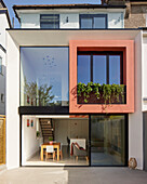Modernes Haus mit korallenroter Fassade und bodentiefen, großen Fenstern in London