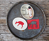 DIY-Schablonen für Tiersilhouetten mit Farbtube auf Metalltablett