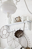 Kitchen shelf with antique baking tin, cake racks and white porcelain pots