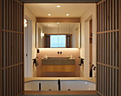 Badezimmer mit Holzlamellen, Waschbecken und Spiegel