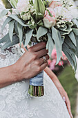 Bride with wedding ring and wedding bouquet of pink roses